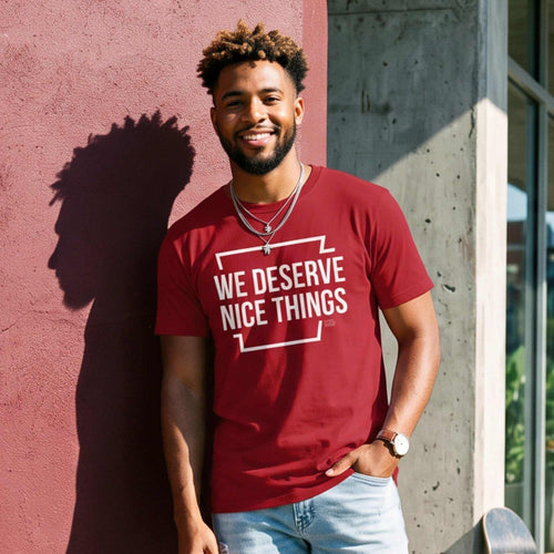 Model wearing a red Arkansas Shirt that says 'We Deserve Nice Things', showcasing Northwest Arkansas culture.